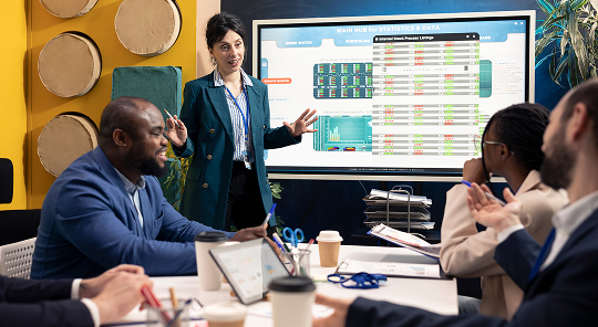 A group of people having a meeting, where they are talking about analytics and data