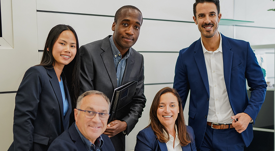 Group photo of 5 colleagues sitting down
