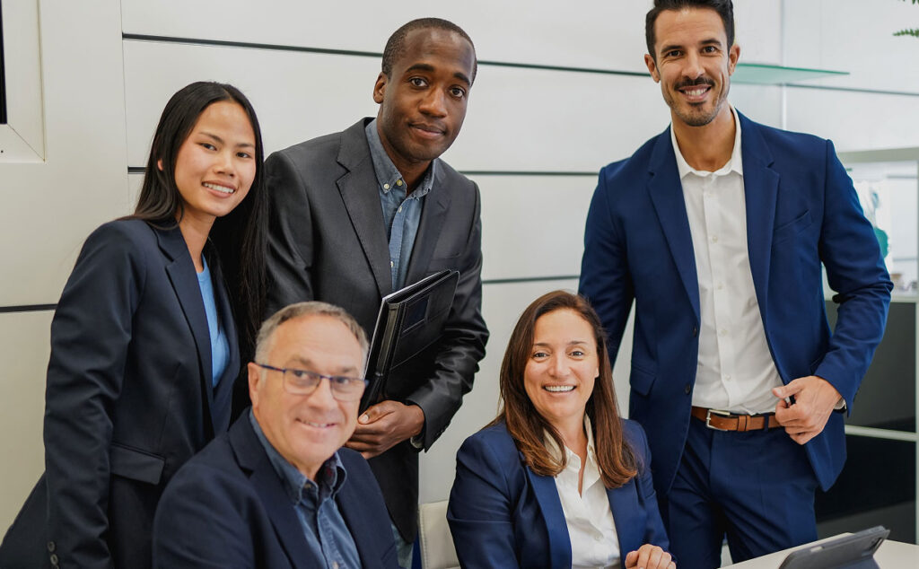 Group photo of 5 colleagues, sitting down